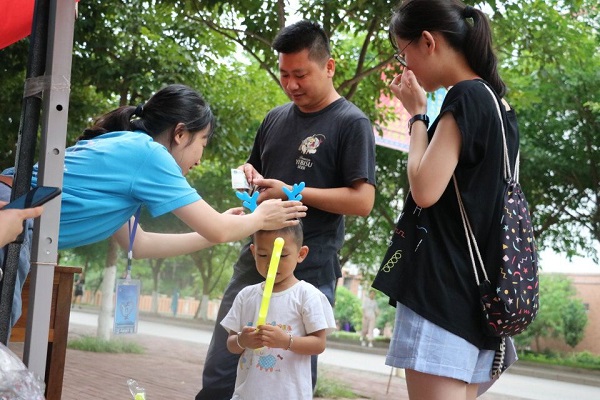 志愿者为小朋友戴上他心仪的物品.jpg